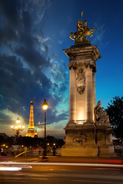 PARIS, Frankreich, 25. August 2016: Spalte auf der Brücke Alexandre III und Eiffelturm bei Sonnenuntergang in Paris, Frankreich