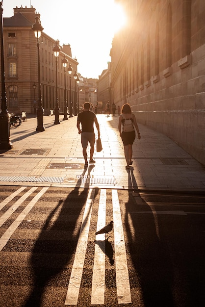 Pariser Straßenszene von nicht erkennbaren Menschen, die bei Sonnenuntergang spazieren gehen