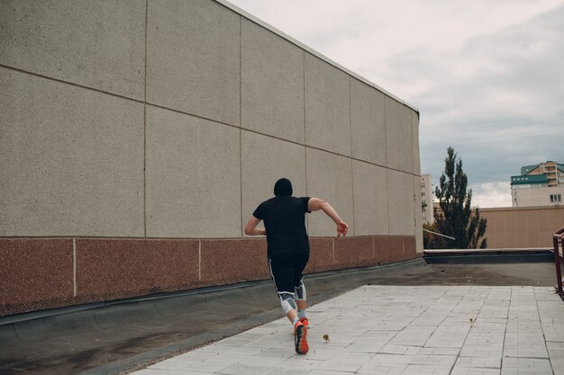 Parkour joven haciendo trucos acrobáticos y volteando saltando alto