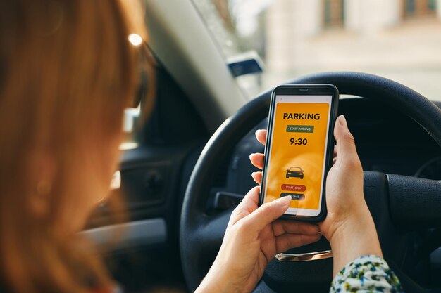 Foto parkplatzfahrer bezahlt mit dem smartphone für das parken frau mit einer mobilen parkplatz-app auf dem smartphone