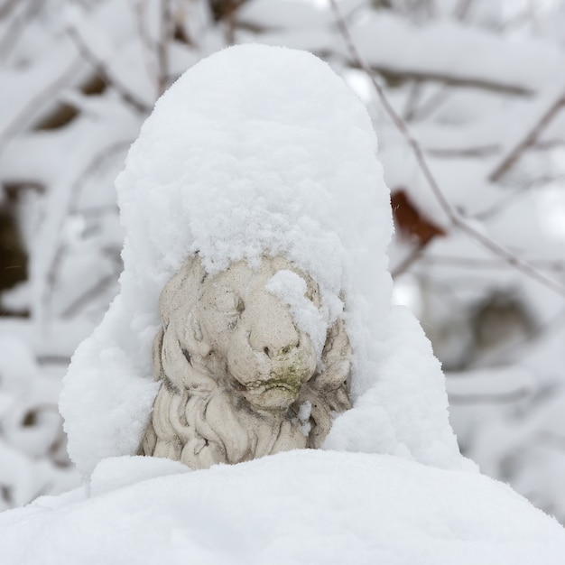 Parkskulptur eines schneebedeckten Löwen