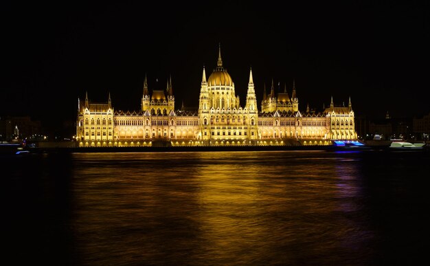 Foto parlamento de budapeste à noite perto do rio danúbio