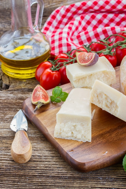 Parmesankäse auf Holzschneidebrett mit Kirschtomaten