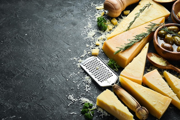 Parmesankäse und Snacks auf einem Steintisch. Ansicht von oben. Auf konkretem Hintergrund.