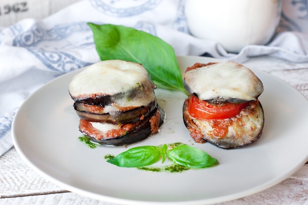 Parmigiana di melanzane: berenjena al horno - italia, cousine de sicilia. Sobre la mesa de madera.