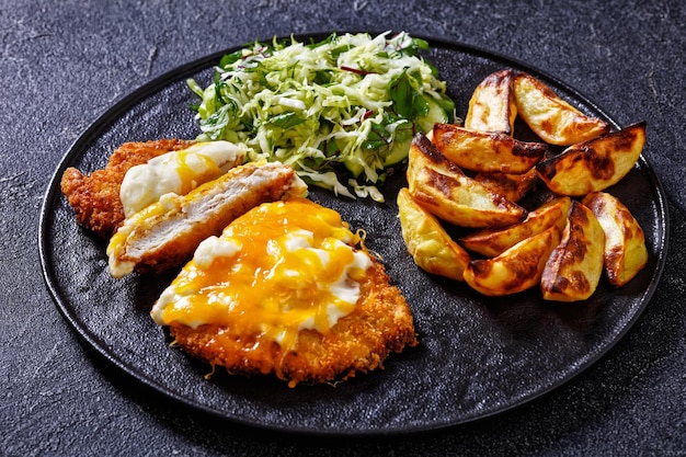 Parmo de frango com salada de repolho e batatas assadas