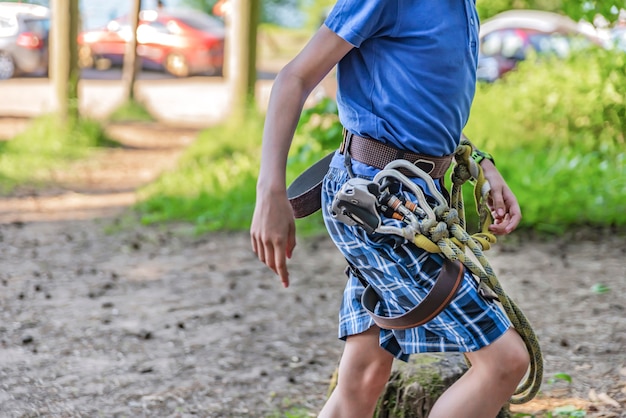 Parque de Aventuras Forestales. Un niño con equipo especial supera los obstáculos en el parque forestal de aventuras. Banner para publicidad y lugar para insertar texto.