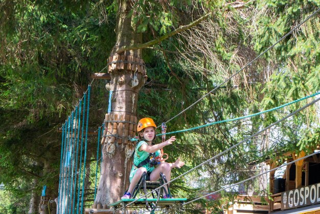 Parque de cable de escalada de aventura: personas en curso en casco de montaña y equipo de seguridad