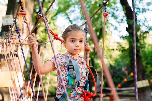 Foto parque de cuerdas. el niño pasa el obstáculo en el parque de cuerdas.