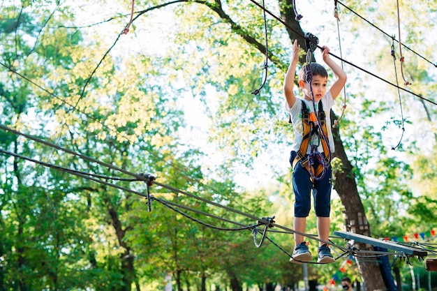 Parque de cuerdas. El niño pasa el obstáculo en el parque de cuerdas.