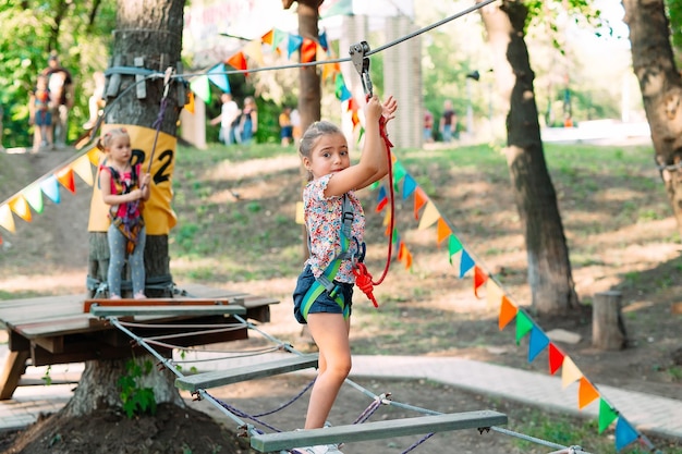 Parque da corda. A criança passa o obstáculo no parque de cordas.