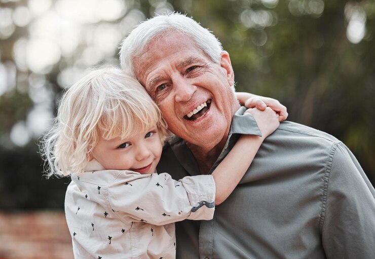 Foto parque de abraços e retrato do avô com a criança para vincular o relacionamento e relaxar juntos ao ar livre família feliz e avô abraçam a criança na natureza para afeição rir e amar no fim de semana
