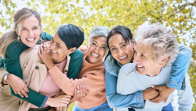 Parque de amigos e retrato de grupo de mulheres desfrutando de um tempo de qualidade e relaxando na aposentadoria juntos Amizade de diversidade e rostos de mulheres idosas felizes com sorriso abraçando e rindo