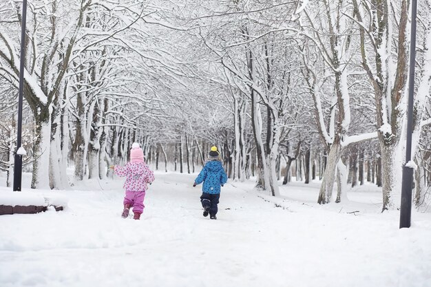 Parque de inverno coberto de neve e bancos. parque e píer para alimentar patos e pombos. a família em uma caminhada na neve cobriu o parque de outono.