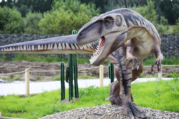 Parque de dinosaurios. Un dinosaurio en el fondo de la naturaleza. Dinosaurios de juguete en el parque de atracciones.