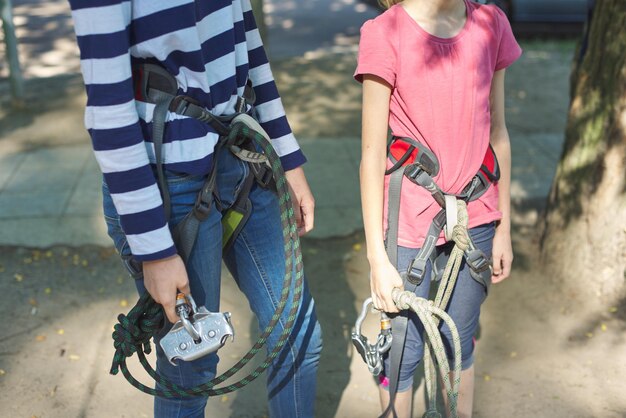 Parque de diversiones y recreación activa al aire libre, los niños se preparan para un salto bungee, se ponen cinturones de seguridad