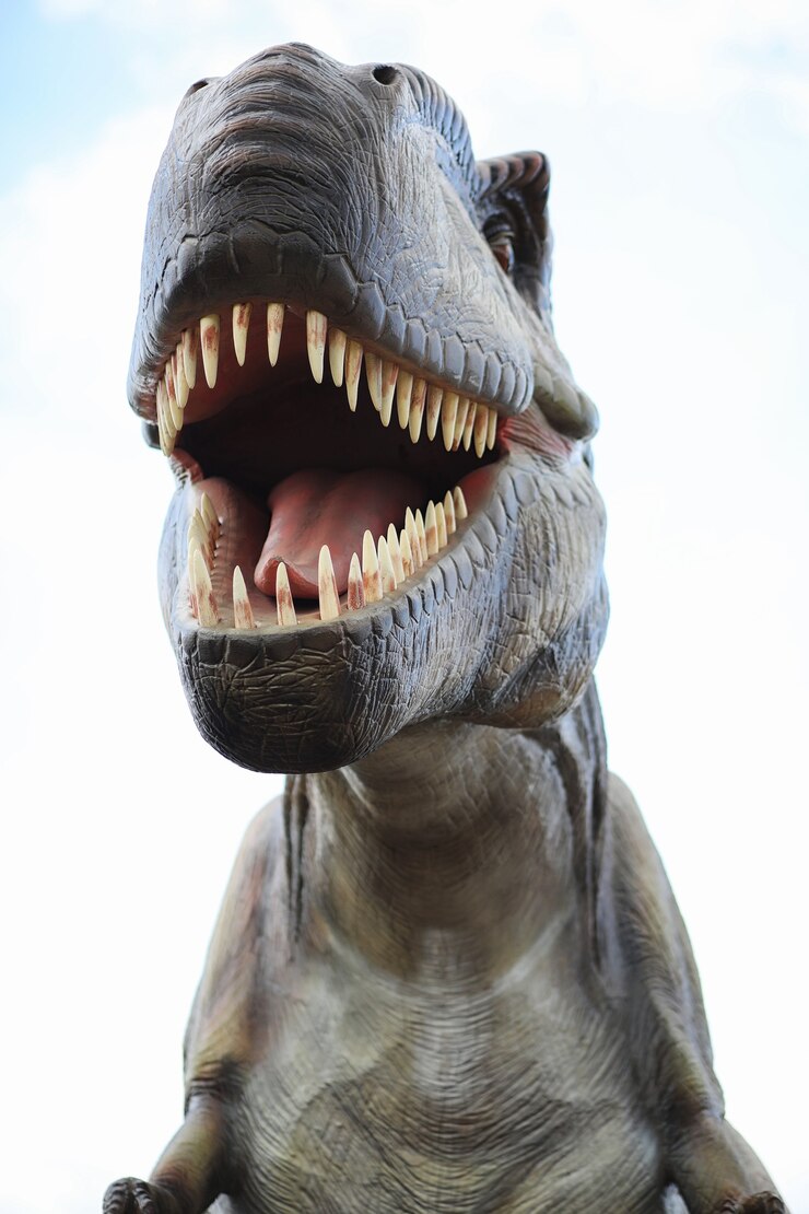 Foto parque dos dinossauros. um dinossauro no fundo da natureza. dinossauros de brinquedo no parque de diversões.