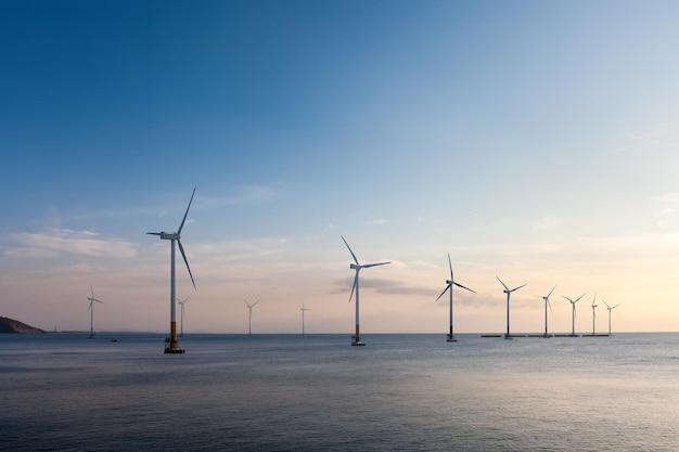 Parque eólico marino al atardecer fondo de energía renovable
