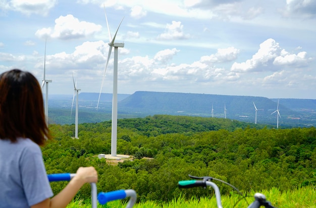 Parque eólico con mujer montando en bicicleta en primer plano Energía eólica Energía eólica Energía renovable sostenible