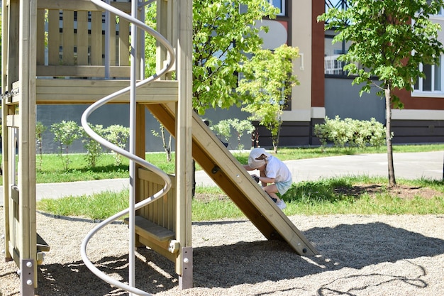 Parque infantil moderno A menina sobe um escorrega de madeira Atividades ao ar livre Entretenimento de verão