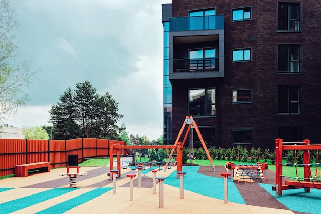 Parque infantil no complexo moderno europeu do bairro de edifícios residenciais de apartamentos. Com instalações ao ar livre.