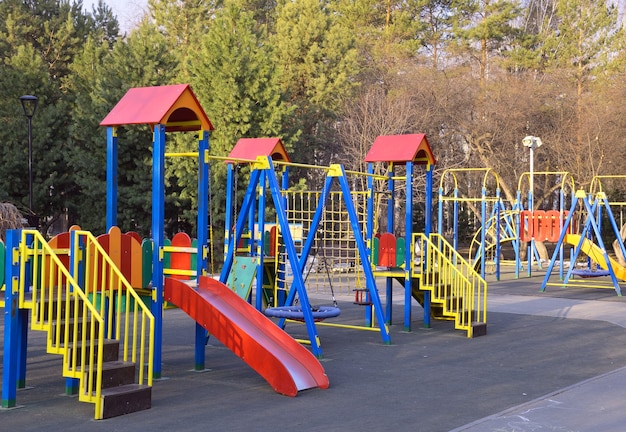 Parque infantil no parque Baloiços coloridos, escadas, escadas, barras horizontais