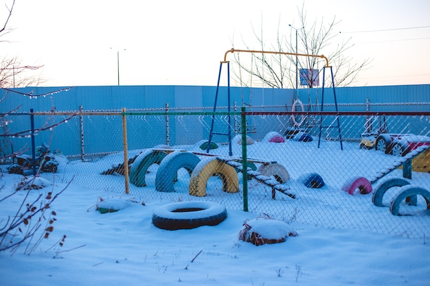 Parque infantil en el polígono industrial de la ciudad, cubierto de nieve.