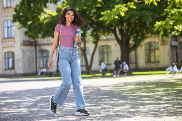 En el parque. Una linda chica en jeans caminando en el parque.