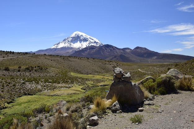 Parque Nacional Sajama rodeado de montañas nevadas con nubes negras rodeadas de vegetación seca Bolivia