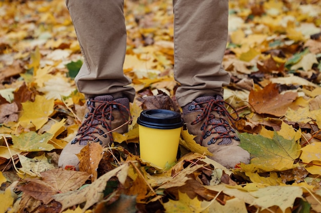 Parque de otoño y café para llevar en un vaso de papel.