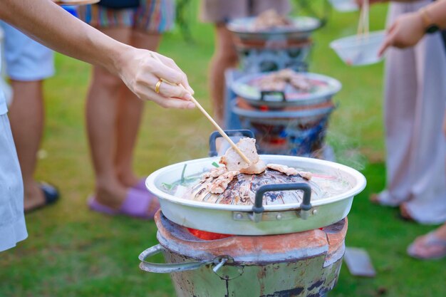 Parrilla a mano Cerdo o carne con verduras y sopa en la fiesta de pan caliente del grupo de amigos y pandillas contra la naturaleza al aire libre El estilo tradicional de barbacoa tailandesa es famoso en Tailandia