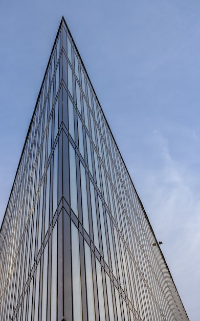Una parte aguda de un edificio moderno dirigido hacia el cielo azul.