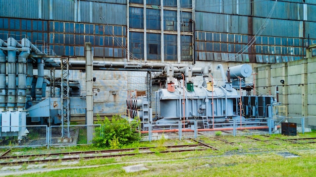 Parte de una antigua planta de energía eléctrica fuera de la parte trasera de una gran planta de energía en verano