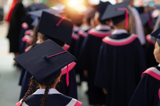 La parte de atrás de los graduados camina para asistir a la ceremonia de graduación en la universidad Concepto de Educación Exitosa en la Escuela Secundaria Grado Felicitado