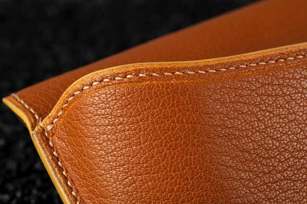 Parte de una cartera o estuche de cuero marrón con costuras