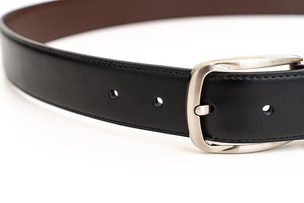 Parte del cinturón de cuero negro y marrón de doble cara sobre un blanco