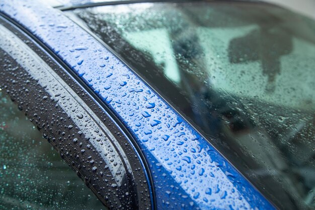 Parte del coche después de la lluvia Gotas de agua