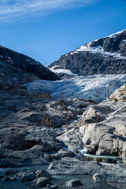 Parte da geleira Nigardsbreen cercada por altas montanhas cobertas de neve