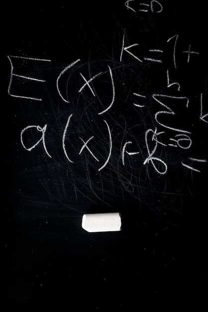 Foto parte de fórmulas matemáticas escritas com giz branco no fundo do quadro preto