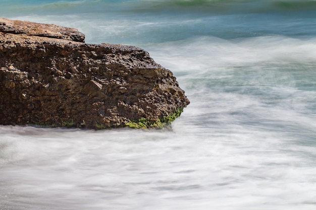 Parte de rocha de pedra no mar na costa do mar movimento turvo da água