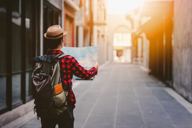 Foto parte de trás do turista homem procurando direção certa com o mapa na rua