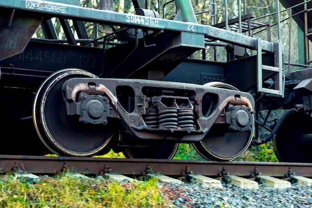 Foto parte de um vagão de carga com rodas enormes durante o movimento do trem nos trilhos