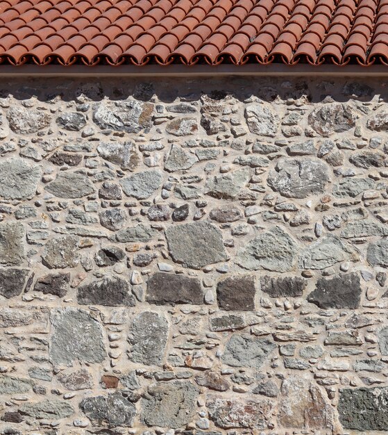 Parte de uma parede de pedra antiga e fundo natural ou textura do telhado