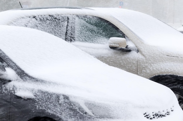 La parte delantera del coche el capó bajo una capa de nieve