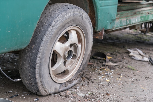 La parte delantera de un coche de la chatarra; un mal neumático