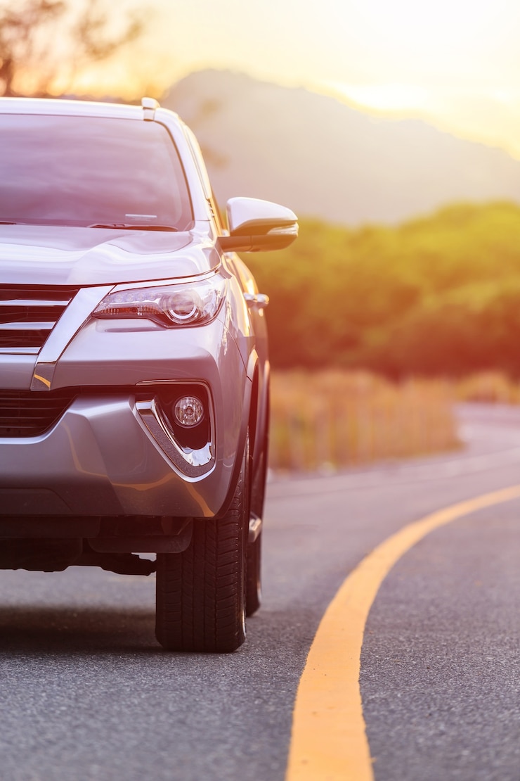 Parte delantera del nuevo estacionamiento plateado SUV en la carretera de asfalto