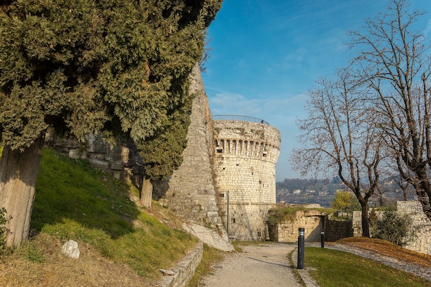 Parte do castelo da cidade de Brescia em um dia ensolarado de inverno. Uma vista da torre. Castello di Brescia, Lombardia, Itália. Castelo medieval com ameias, uma torre, ponte levadiça e muralhas.