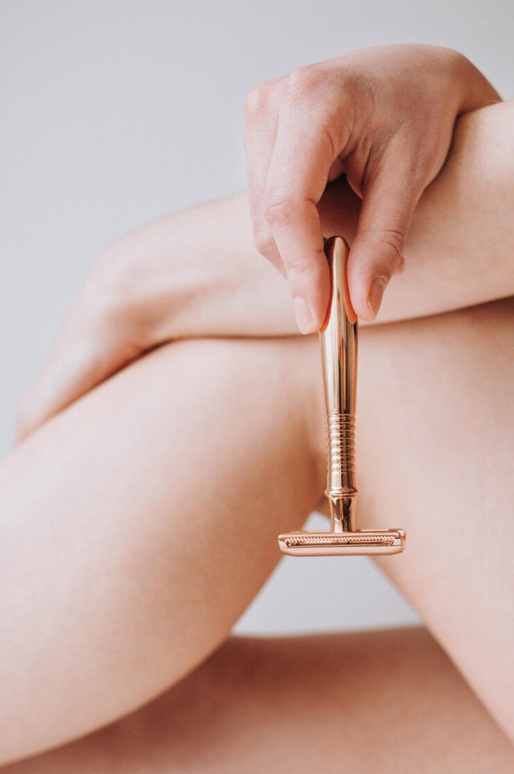 Foto parte do corpo feminino com uma lâmina de barbear de segurança