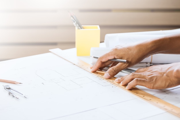 Parte do engenheiro masculino trabalhando no espaço de trabalho. Conceito de construção de construção em projeto de casa.