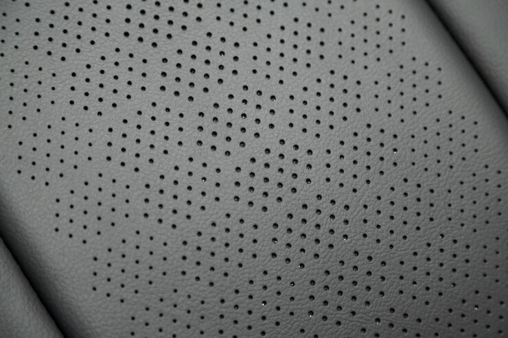 Foto parte dos detalhes em couro do assento para a cabeça do carro. assento de automóvel em pele perfurada cinzenta e solta. textura da pele